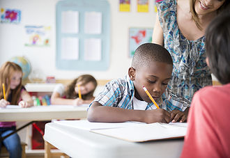 Boy writing at desk in school